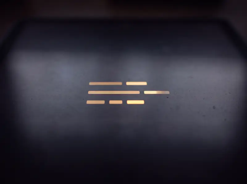 Eine einzelne Gruppe goldener Lichtbalken auf einer dunklen Displayfläche